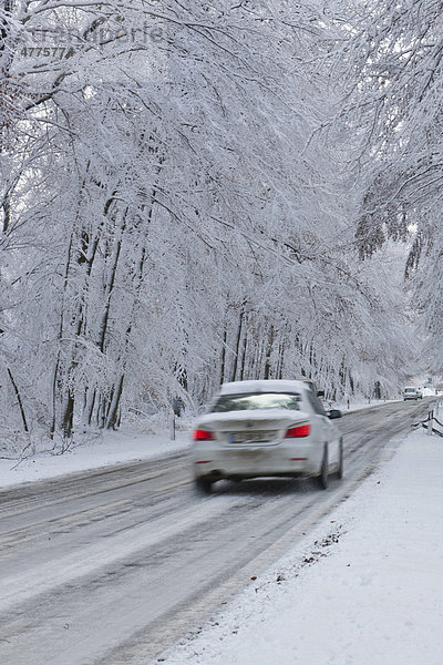 Verschneite Landstraße im Winter mit Verkehr  Hessen  Deutschland  Europa
