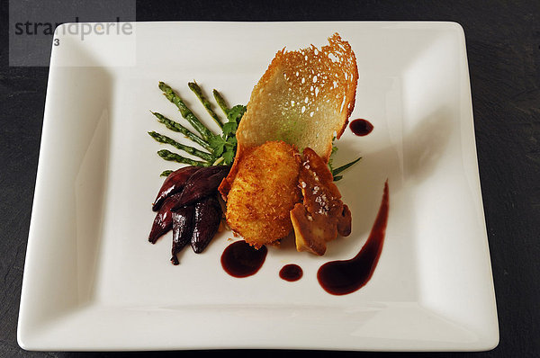Gebratene Entenleber mit pochiert-gebackenem Ei  wildem Spargel und rotem Zwiebel-Confit auf einem weißen Teller serviert  Food  Haute Cuisine