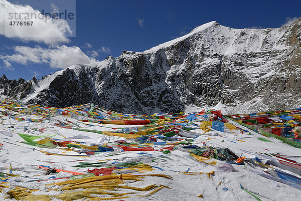 Buddhistische Gebetsfahnen im Schnee am Gipfel des Dolma La Pass  5700m  auf der Umrundung des heiligen Mount Kailash  tibetisch: Kang Rinpoche  6638 m  mit Westtal der Kailash Kora  Westtibet  Provinz Ngari  Tibet  China  Asien