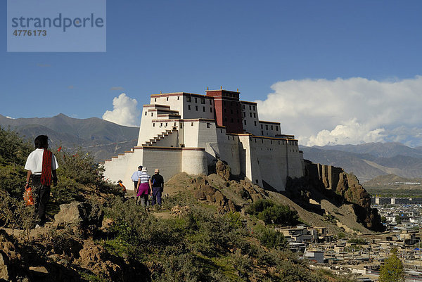 Pilger und Touristengruppe vor wiederaufgebauter Festung Shigatse Dzong  mit tibetischer Altstadt von Shigatse  Zentraltibet  Tibet  China  Asien