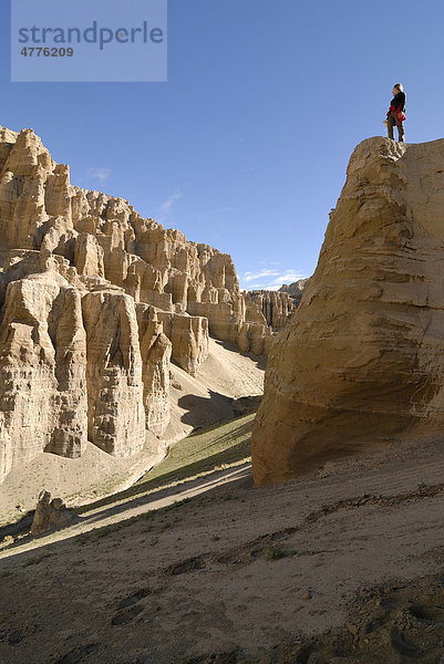 Frau steht auf Sandsteinfelsen in trockener Landschaft im alten Königreich Guge  Sutley Canyon  Westtibet  Provinz Ngari  Tibet  China  Asien