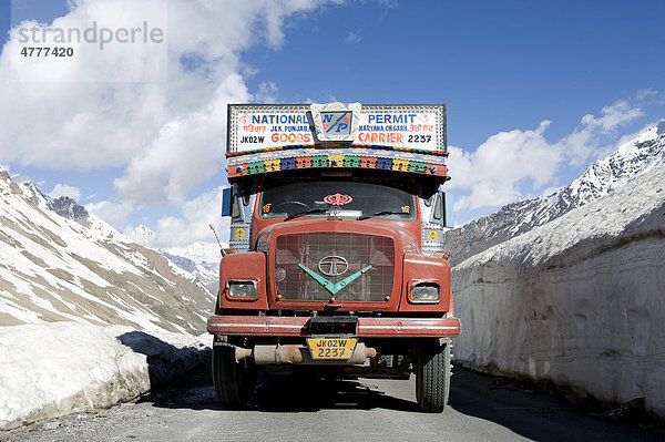 Passstraße Manali-Leh-Highway  alter roter Tata LKW auf Straße zwischen Schneewand  bei Keylong  Distrikt Lahaul und Spiti  Bundesstaat Himachal Pradesh  Indien  Südasien  Asien