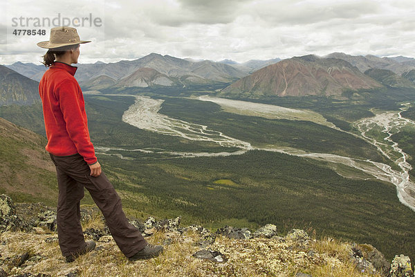 Junge Frau beim Wandern genießt die Aussicht  Wind River Valley  nördliche Mackenzie Mountains Gebirgskette  Yukon Territorium  Kanada