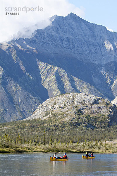 Kanufahrer paddeln auf dem Wind River  Kanus  hinten nördliche Mackenzie Mountains Gebirgskette  Yukon Territorium  Kanada