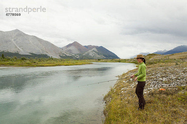 Junge Frau beim Angeln am Wind River  Mackenzie Mountains  Yukon Territory  Kanada