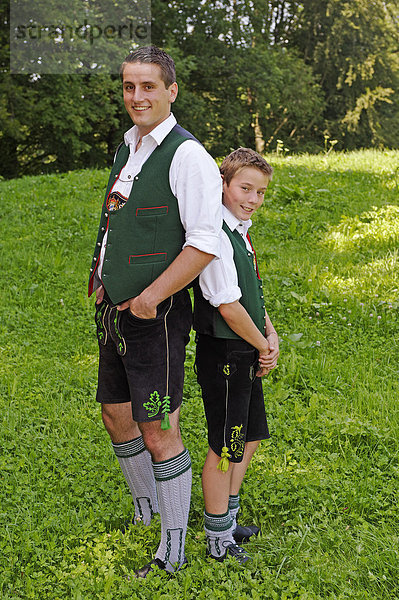 Junger Mann mit seinem Bruder  beide in oberbayerischer Tracht  Lederhose  Oberbayern  Bayern  Deutschland  Europa