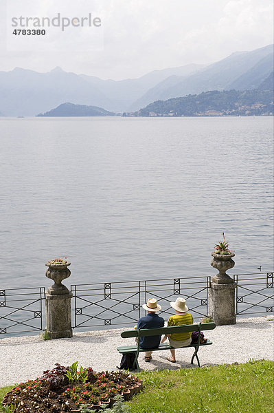 Älteres Paar auf einer Gartenbank am See  Villa Monastero  Varenna  Comer See  Lombardei  Italien  Europa