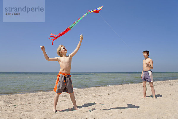 Zwei Jungen lassen einen Drachen steigen  Strand von Timmendorf auf der Insel Poel  Mecklenburg-Vorpommern  Norddeutschland  Deutschland  Europa