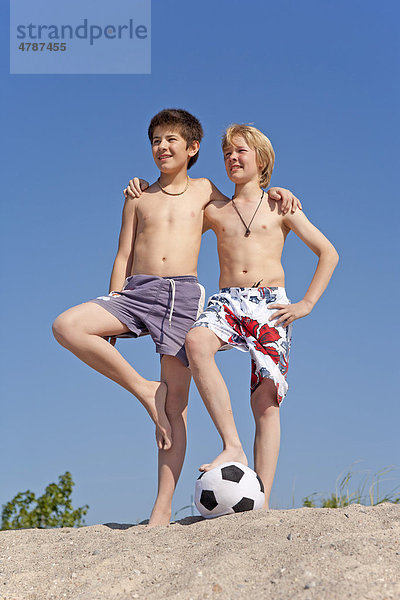 Zwei Jungen mit einem Fußball am Strand von Timmendorf auf der Insel Poel  Mecklenburg-Vorpommern  Norddeutschland  Deutschland  Europa