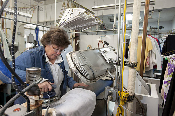 Mary Kay Valencia  Lionheart Cleaners  einer Wäscherei und Reinigung  bügelt ein Kleidungsstück  Broomfield  Colorado  USA  Amerika