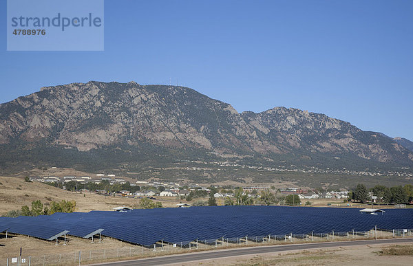 Solaranlage  Photovoltaik-Anlage  errichtet auf einer ehemaligen Deponie der US-Armee  Fort Carson  kontaminiertes Land wird für die Erzeugung von erneuerbarer Energie benutzt  erzeugt 3200 MWh Strom pro Jahr  Berg Cheyenne Mountain hinten  Colorado Springs  Colorado  USA