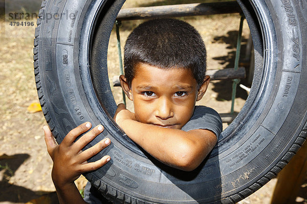 Junge blickt durch Autoreifen  Fortaleza  Bundesstaat Cear·  Brasilien  Südamerika
