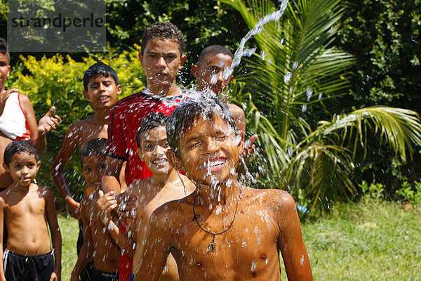 Jungen spritzen sich mit Wasserschlauch ab  Fortaleza  Bundesstaat Cear·  Brasilien  Südamerika