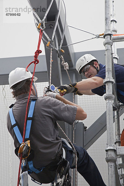 Ein Ausbilder kontrolliert die Kletterausrüstung eines Studenten während eines Sicherheits-Kletterkurses im Studiengang Windkraftanlagentechnik  Grand Rapids Community College  Grand Rapids  Michigan  USA  Nordamerika