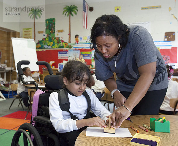 'Ein Lehrerin hilft einem Mädchen in einem Rollstuhl in einer Klasse der Oakman Grundschule