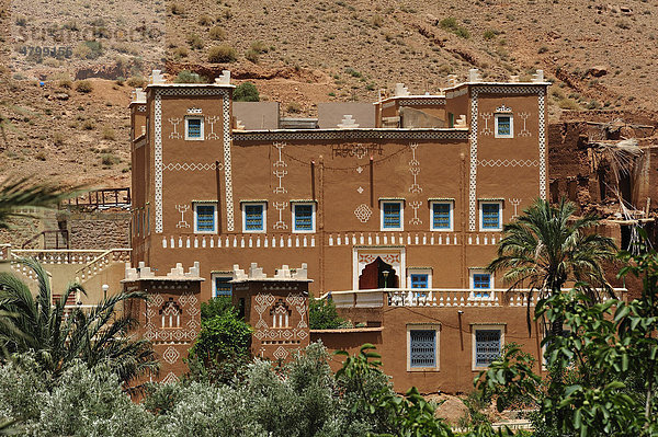 Typisches Lehmhaus  Kasbah  Wohnburg der Berber  mit traditionellen Ornamenten und Stammeszeichen bemalt  bei Tinerhir  Hoher Atlas  Südmarokko  Afrika