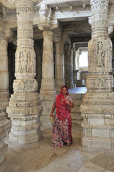 Junge indische Frau im traditionellen Sari in der Innenhalle mit kunstvoll verzierten Säulen im Marmortempel Ranakpur  Tempel der Jain-Religion  Rajasthan  Nordindien  Indien  Asien