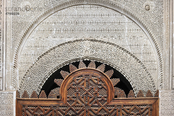 Detail der Medersa Attarine  Türbogen aus Zedernholz geschnitzt  die Wand ist mit filigranen Stuckornamenten verziert  Koranschule Medersa Attarine  Fes  Marokko  Afrika