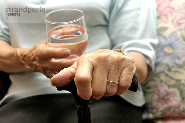 Ältere Frau trinkt ein Glas Wasser