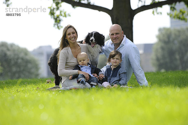 Glückliche Familie mit einem dreijährigen Mädchen  einem sechs Monate alten Jungen und einem Hund