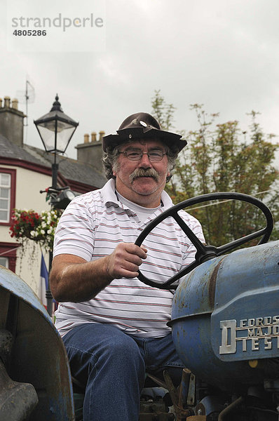 Irischer Farmer auf einem alten Schlepper bei einem Umzug auf dem Stadtfest von Birr  County Offaly  Midlands  Republik Irland  Europa