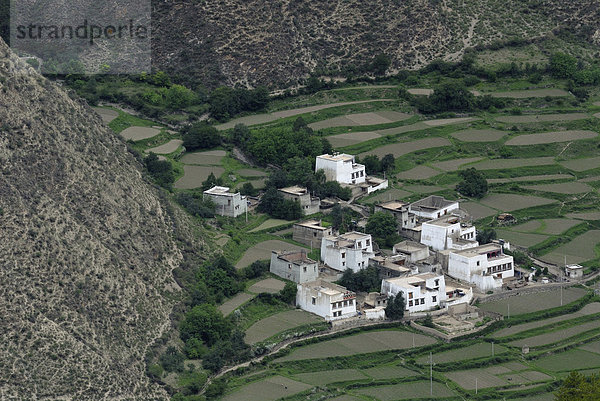 Blick von oben auf die tibetische Architektur eines kleinen Dorfes  Häuser in einem steilen Canyons mit Feldterrassen zum Anbau  Xiangcheng  Chaktreng  Kham  Sichuan  China  Asien