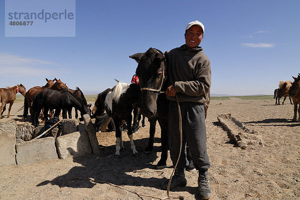 Mongolischer Junge bringt Pferd zum Tränken an ein Wasserloch in der Wüste Gobi  Ömnögov Aimak  Mongolei  Asien