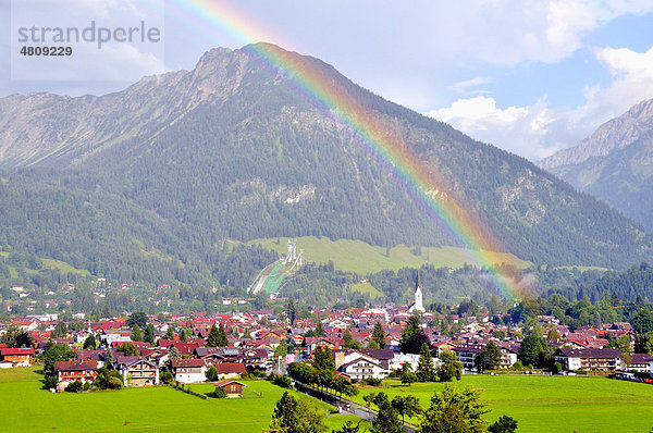 Blick über Oberstdorf mit Regenbogen  dahinter der Schattenberg mit Schattenbergschanze  Oberallgäu  Bayern  Deutschland  Europa