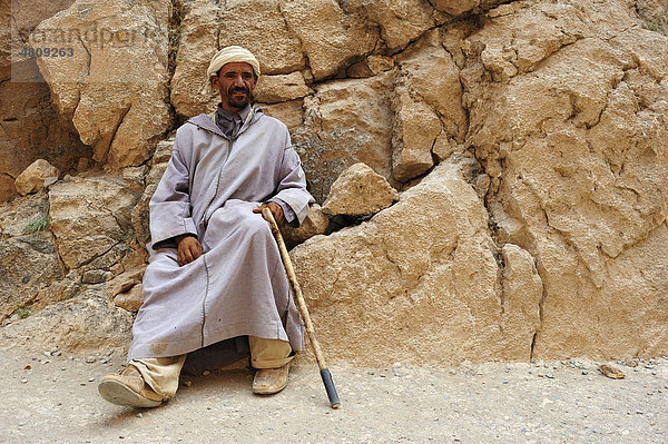 Berber  älterer Mann mit Djellabah und Turban vor einer Felswand  Todra Schlucht  Marokko  Afrika