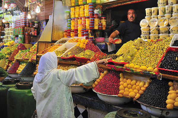 Ältere Frau mit Kopftuch an einem Verkaufsstand im Souk oder Basar  Meknes  Marokko  Afrika