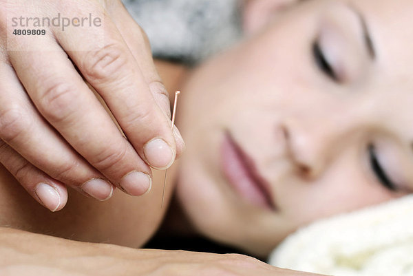 Junge Frau bei Akupunkturbehandlung in einer Naturheilpraxis