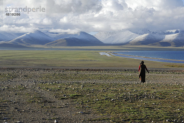 Tibetische Frau  schneebedeckte Gipfel des Nyenchen Thanglha am Namtso See  Himmelssee  Tibet  China  Asien