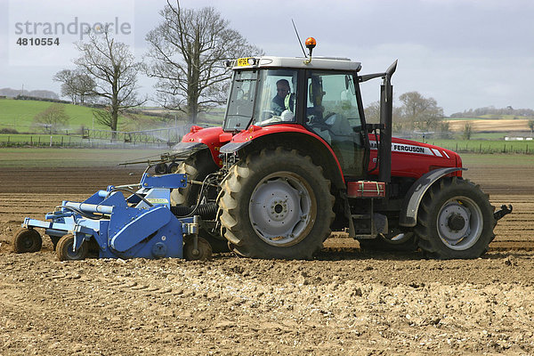 Massey Ferguson-Traktor  Vorbereitung des Ackers für den Anbau von Salat-Spinat  Bewässerung am Heck  Dorset  England  Großbritannien  Europa