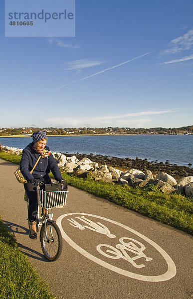 Radfahrerin auf öffentlichem Radweg neben einer Bucht  Poole  Dorset  England  Großbritannien  Europa