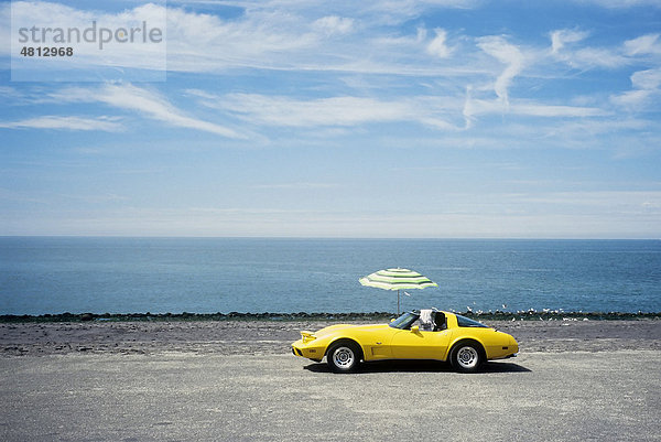 Gelber Chevrolet Corvette mit Sonnenschirm parkt am Meeresufer  Westkapelle  Walcheren  Provinz Zeeland  Niederlande  Benelux  Europa