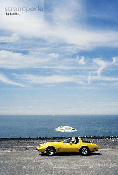 Gelber Chevrolet Corvette mit Sonnenschirm am Meeresufer  Westkapelle  Walcheren  Provinz Zeeland  Niederlande  Benelux  Europa
