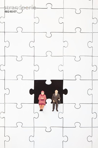 Figuren auf Puzzleteil sitzend