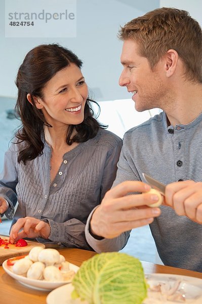 Mann und Frau kochen in der Küche  lächelnd