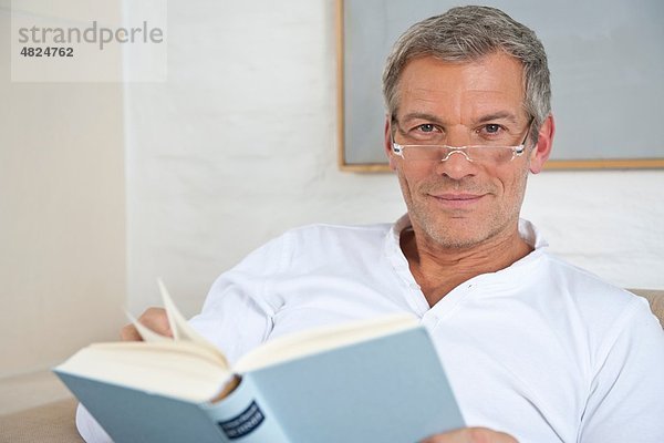 Reifer Mann liest Buch  lächelnd  Porträt