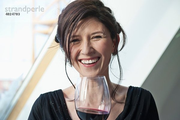 Reife Frau mit Weinglas  lächelnd  Portrait
