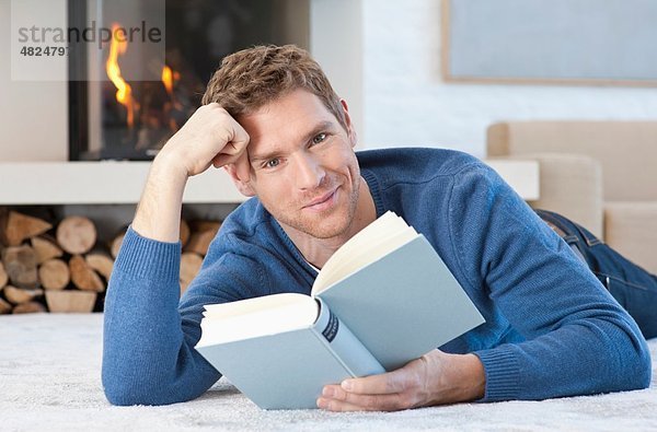 Mittlerer Erwachsener Mann beim Lesen zu Hause  Porträt