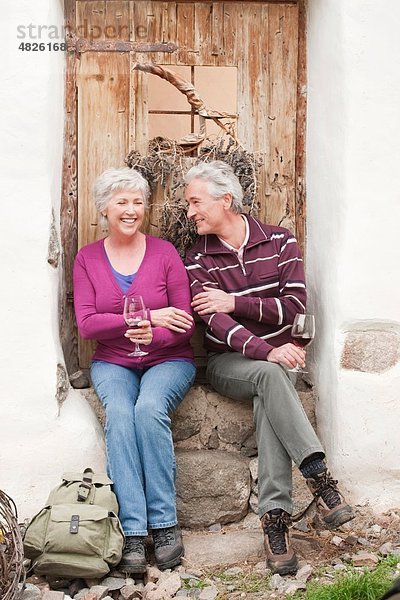 Italien  Südtirol  reifes Paar mit Weinglas auf der Berghütte