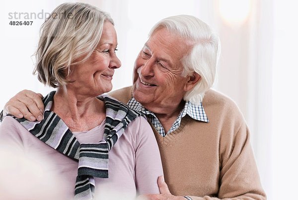 Deutschland  Wakendorf  Seniorenpaar schaut sich an  lächelnd