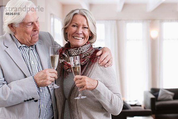 Deutschland  Wakendorf  Seniorenpaar mit Schaumwein  lächelnd