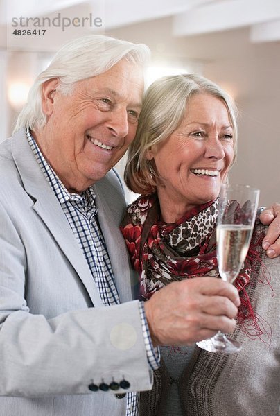 Deutschland  Wakendorf  Seniorenpaar mit Schaumwein  lächelnd