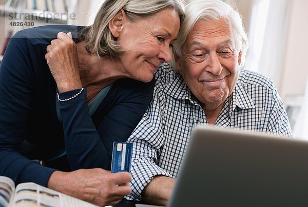 Senior Frau mit Kreditkarte und Mann mit Laptop