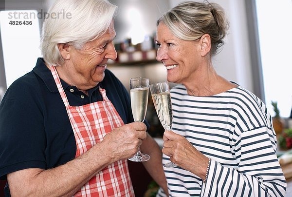 Deutschland  Wakendorf  Seniorenpaar mit Getränk  lächelnd