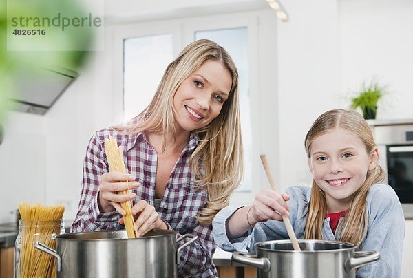 Deutschland    Mutter und Tochter beim Kochen von Spaghetti