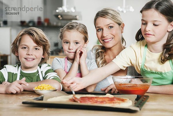 Deutschland    Mutter und Kinder in der Küche machen Pizza