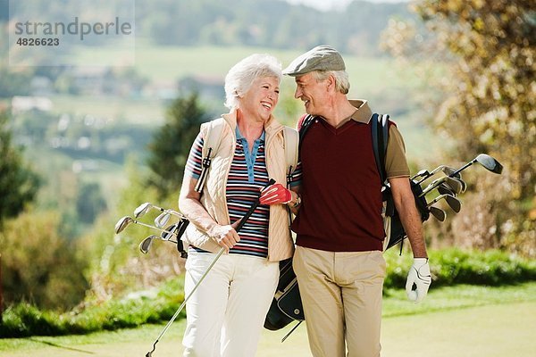 Italien  Kastelruth  reifes Paar auf dem Golfplatz  lächelnd
